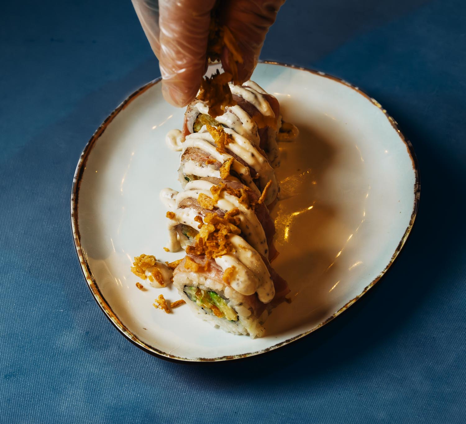 Sushirol op een bord wordt afgemaakt met saus