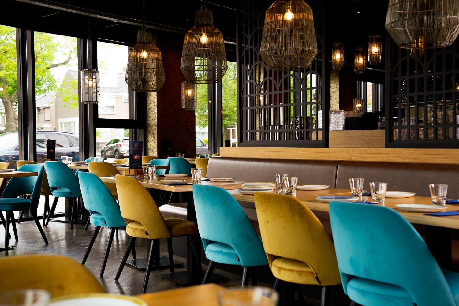 Restaurantzaal van Indrapoera met turquoise en gele stoelen